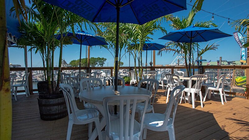 Outdoor patio seating with multiple tables and palm trees